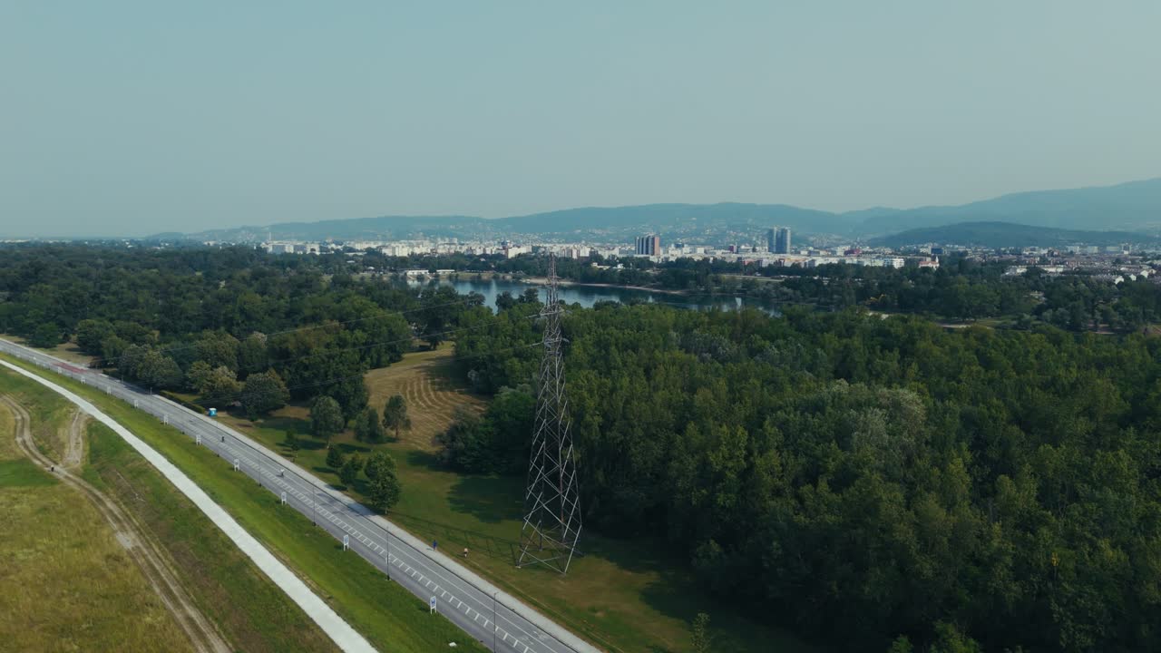 aerial view of forest and power line with Lake Jarun and Zagreb city in background