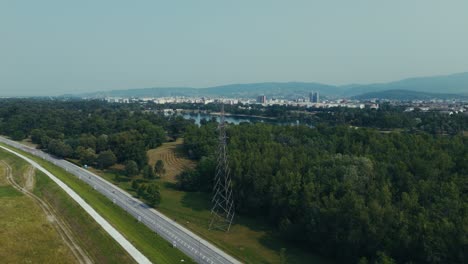 aerial view of forest and power line with lake jarun and zagreb city in background
