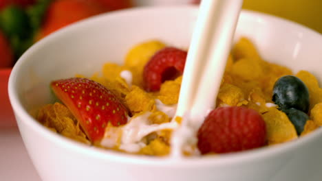 la leche se vierte en un cuenco de cereales con bayas