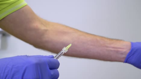 doctor preparing a vaccine and removing the cap of the injection needle and testing by removing the air with protecting gloves in a research lab - close up - 50fps