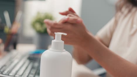 shot of a woman's hand disinfecting her hands in the office before starting to work on the computer, hygiene care, protection against bacteria, viruses, safety in the company