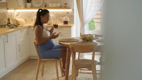 a pregnant woman enjoying her daily routine at home, relaxing in the living room and eating in the kitchen. the scene highlights comfort, maternity, and moments of self-care in a cozy setting