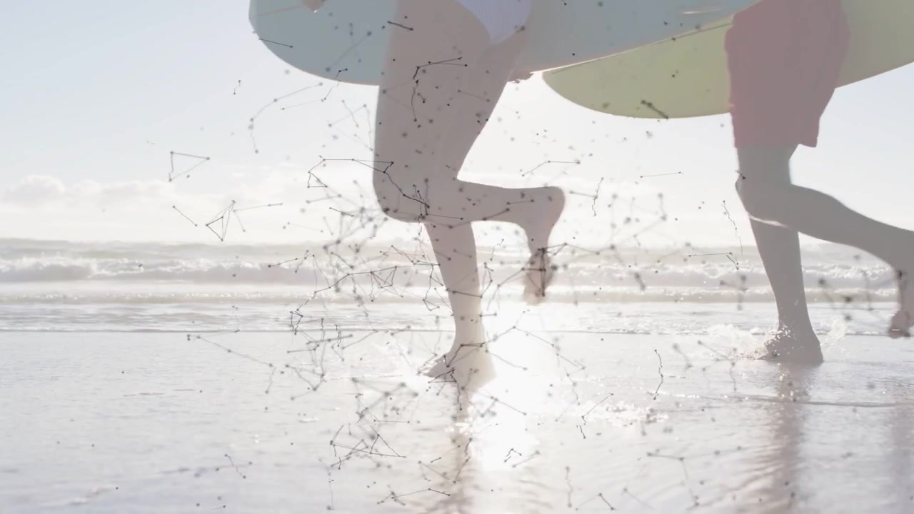Par kommer inn fra høyre, løper på våt sand, med et teknologinettverk som overlegger surfebrett mot bølger for å surfe