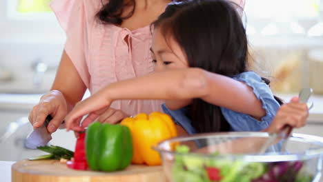 Mädchen-Gibt-Ihrer-Mutter-Eine-Paprika-Zum-Schneiden