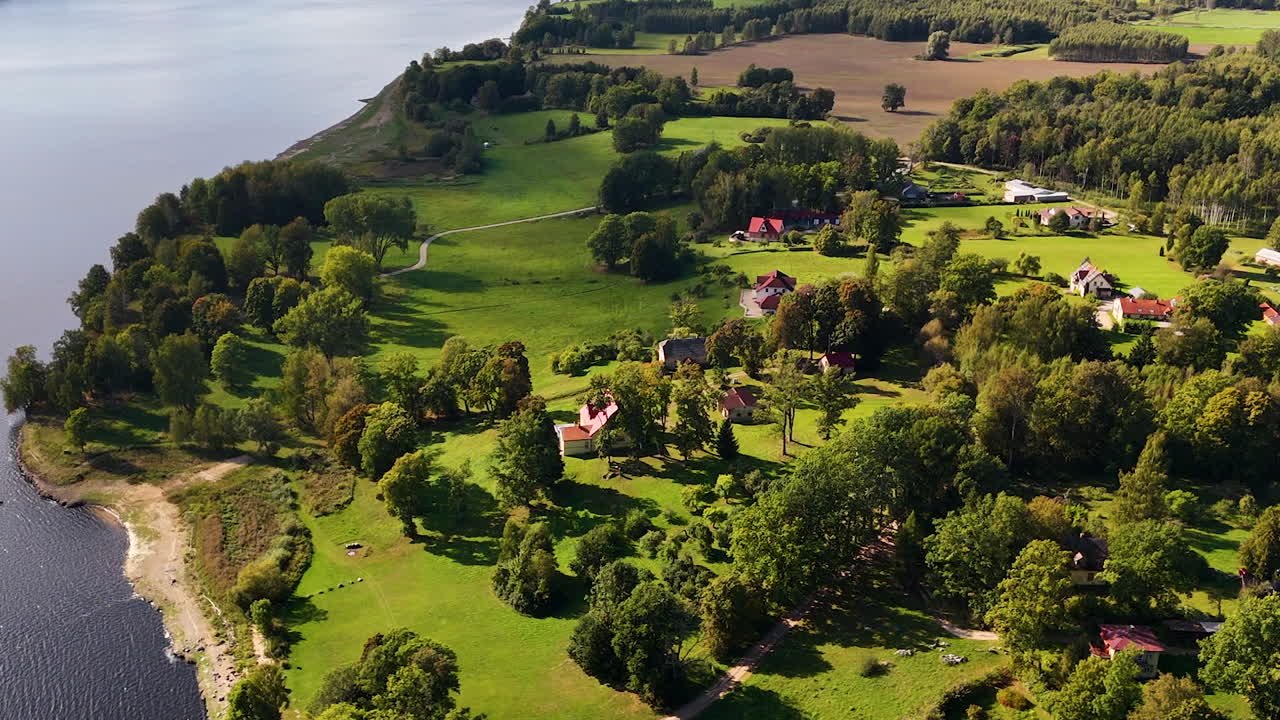 Beautiful homestead with green grass near river, aerial view
