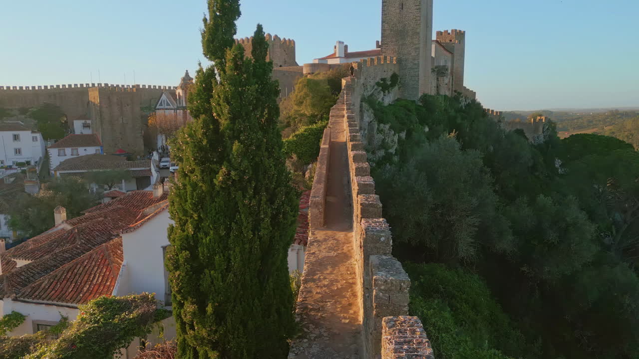 Stone ancient wall stretching along cozy old town aerial view. Medieval castle