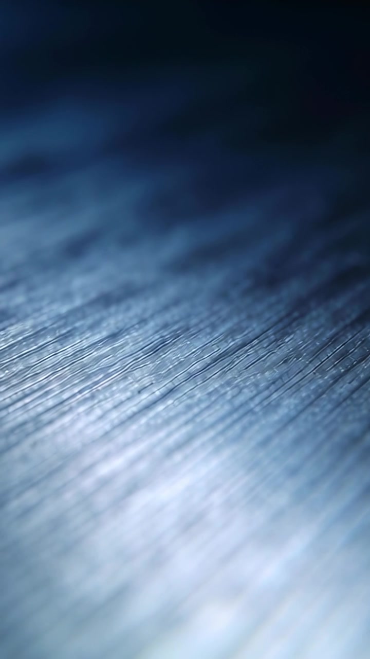Vertical video: Panning camera showing grooved plank in studio under cool light revealing texture