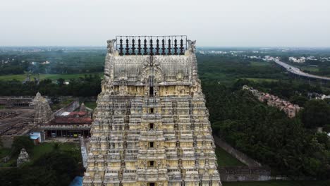 Pull-back-shot-of-Sri-Kanchi-Kamakshi-Amman-Temple-tower-surrounded-by-agricultural-lands-and-suburban-city