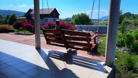 a serene moment on a swing: enjoying nature's beauty under a clear sky with lush gardens and vibrant flowers in the background