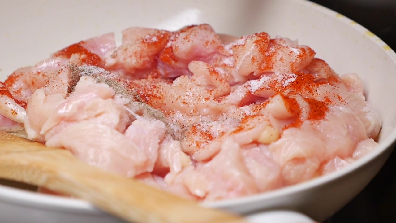 Condire pezzi di pollo crudo in una padella