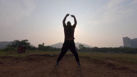 boy-jumping-warmup-jogging-exercise-semi-silhouette-sun-rise-morning-exercise-India-Mumbai-Mira-road,-thane