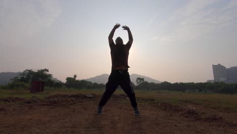 Junge-Springen-Aufwärmen-Joggen-übung-Halb-Silhouette-Sonnenaufgang-Morgens-übung-Indien-Mumbai-Mira-Road,-Thane