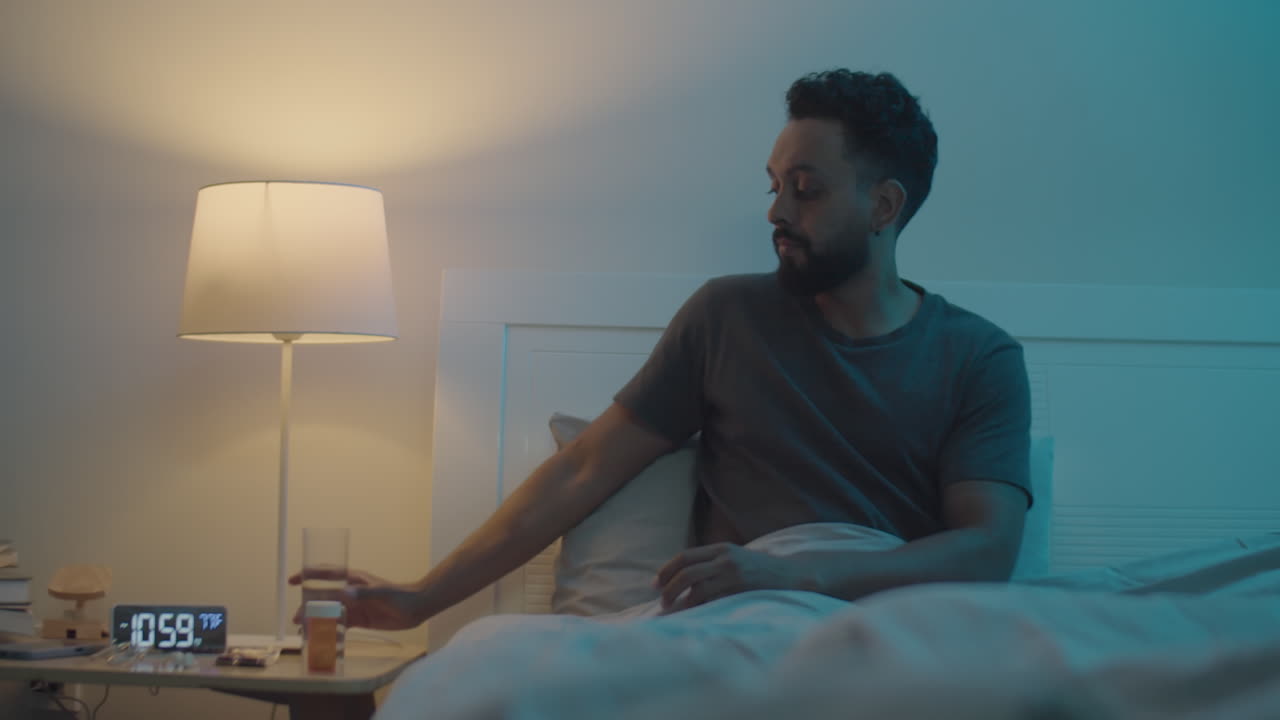 Man Taking Sedative Pills and Going to Sleep