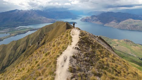 Atemberaubende-Luftaufnahme-Des-Reisenden-Auf-Dem-Roys-Peak-Und-Der-Neuseeländischen-Landschaft-Rund-Um-Den-Lake-Wanaka