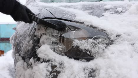 Reinigen-Des-Autoscheinwerfers-Von-Schnee---Nahaufnahme