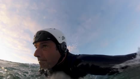 slow motion of male surfer on surfboard riding the waves in the early morning time