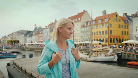 a woman strolls along the canal against the background of famous colorful houses the most popular pl