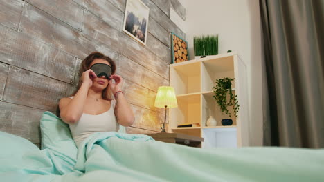 mujer joven con pijama durmiendo con máscara sobre sus ojos