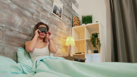 young woman with pajamas sleeping with mask over her eyes