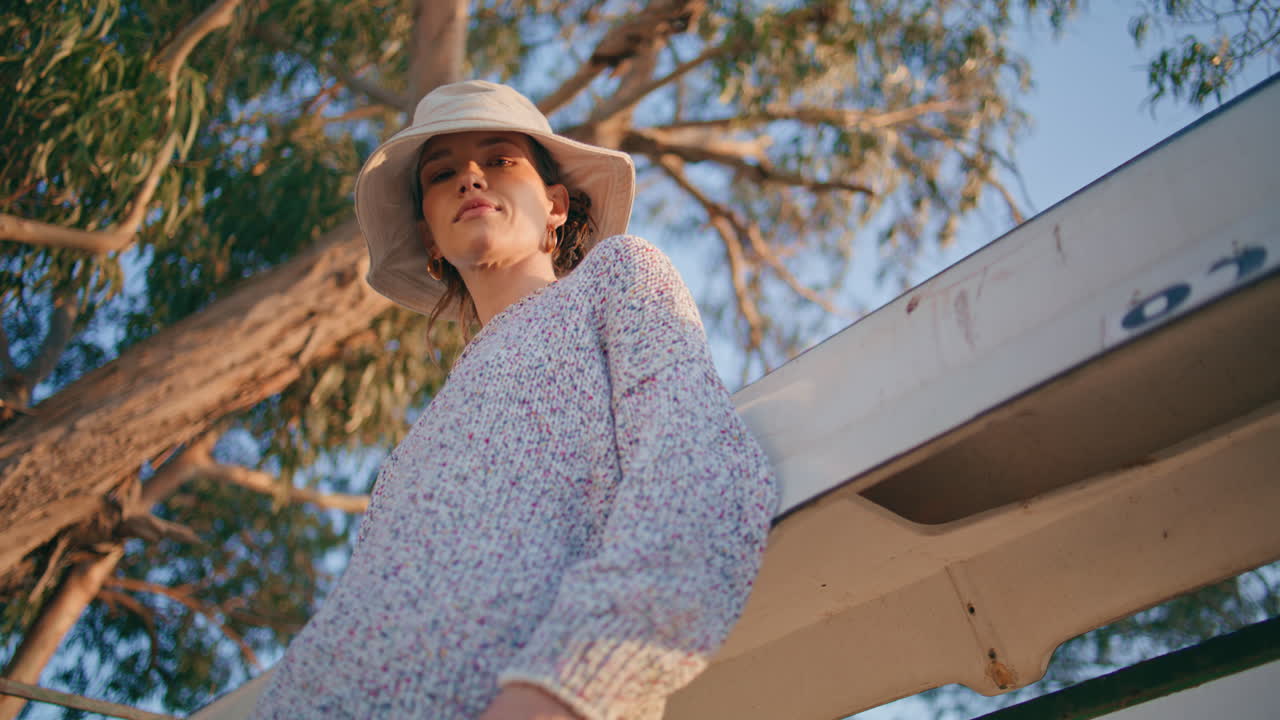 여름의 여자가 야외에서 저녁을 휴식을 취하고 있습니다. 카메라에서 캐주얼하고 편안한 소녀를 보십시오.