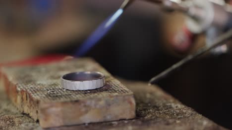 Close-up-of-shaping-ring-with-blowtorch-in-workshop-in-slow-motion