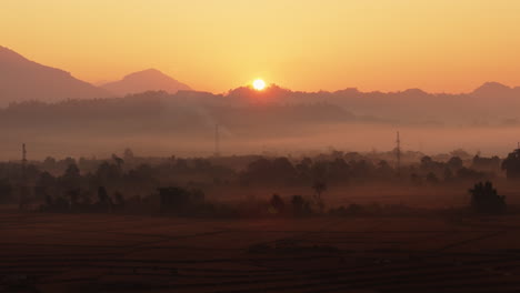 sunrise over misty mountains and fields