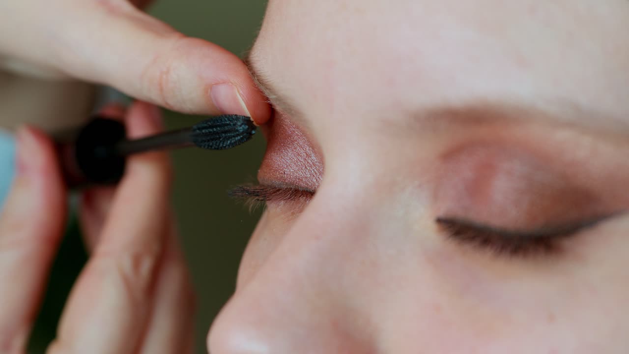 la aplicación de máscara y sombra de ojos