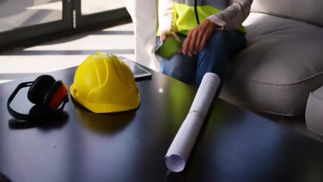 animación de una red de conexiones con iconos sobre una arquitecta caucásica usando un teléfono inteligente