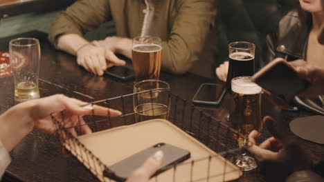 group of friends placing smartphones in container