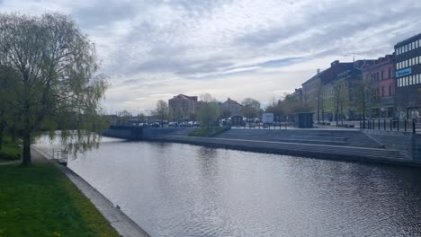 view of the selångersån river in sundsvall, västernorrland county, sweden, on a partly cloudy spring day, the water is slowly moving towards the baltic sea