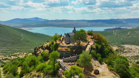 aerial: crkva na valu vracenovici church, sunny, summer day in montenegro