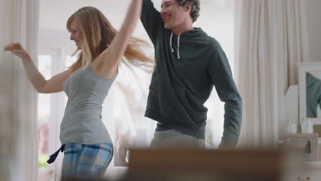 happy-young-couple-dancing-at-home-celebrating-having-fun-weekend-morning-together-enjoying-funny-dance-in-bedroom-successful-relationship-celebration-4k-footage