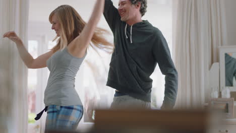 happy young couple dancing at home celebrating having fun weekend morning together enjoying funny dance in bedroom successful relationship celebration 4k footage