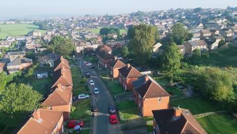 Experience-Dewsbury-Moore-Council-estate-from-above,-captured-by-a-drone,-showcasing-red-brick-housing-and-Yorkshire's-industrial-vista-on-a-sunny-summer-morning