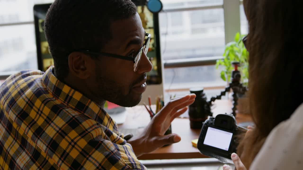 Graphic designers working together at desk in a modern office 4k