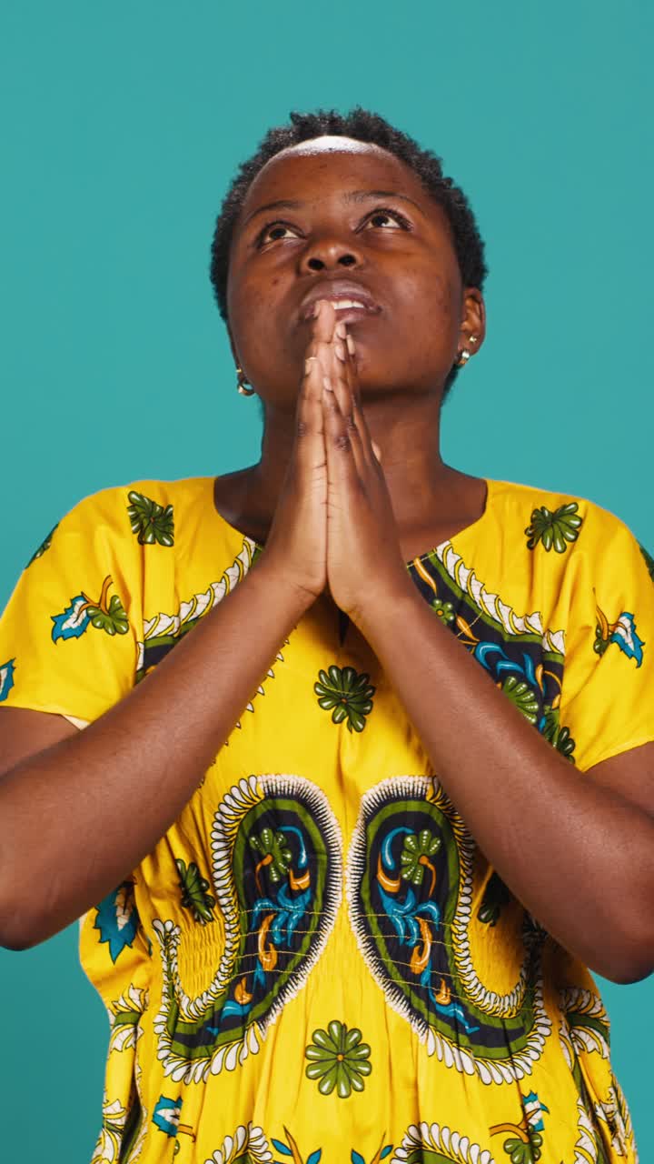 African Woman Praying with Eyes Closed in a Studio
