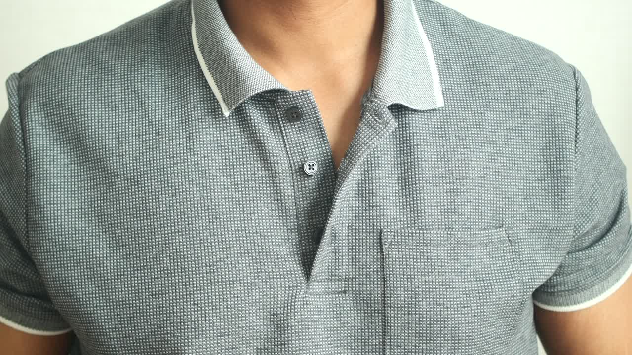 hombre atando una camiseta de polo gris