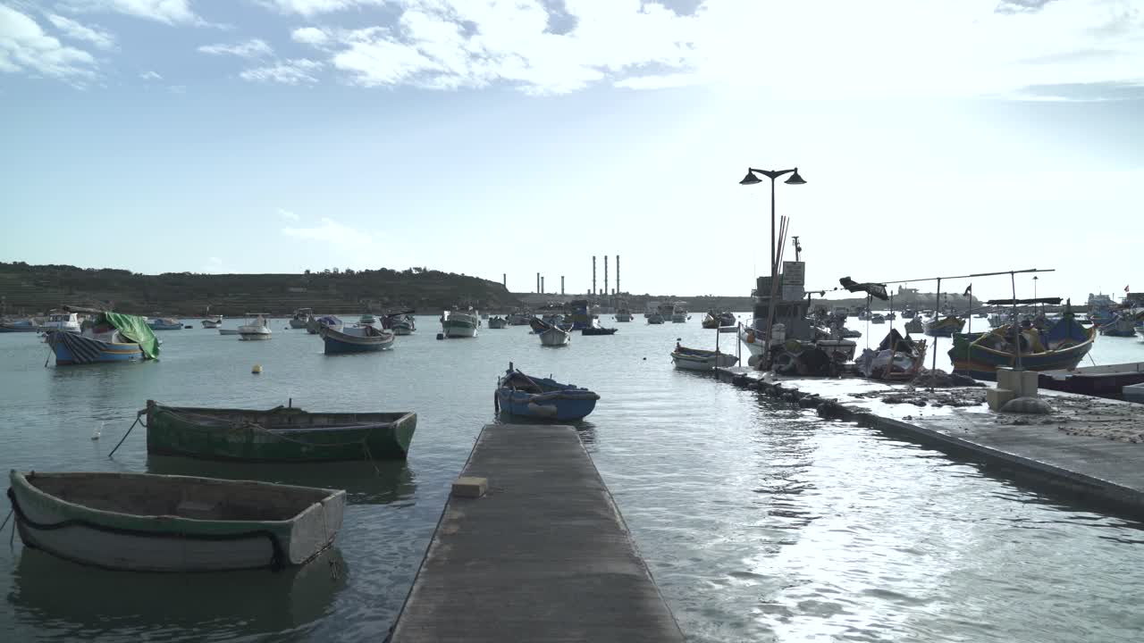 viejos barcos de madera flotando en el tranquilo mar mediterráneo en el pueblo pesquero de marsaxlokk