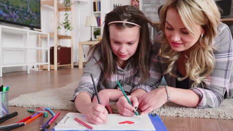 Mother-and-daughter-lying-on-the-floor-carpet-in-living-room