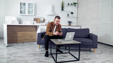 man works on laptop at home. young man working on laptop from home