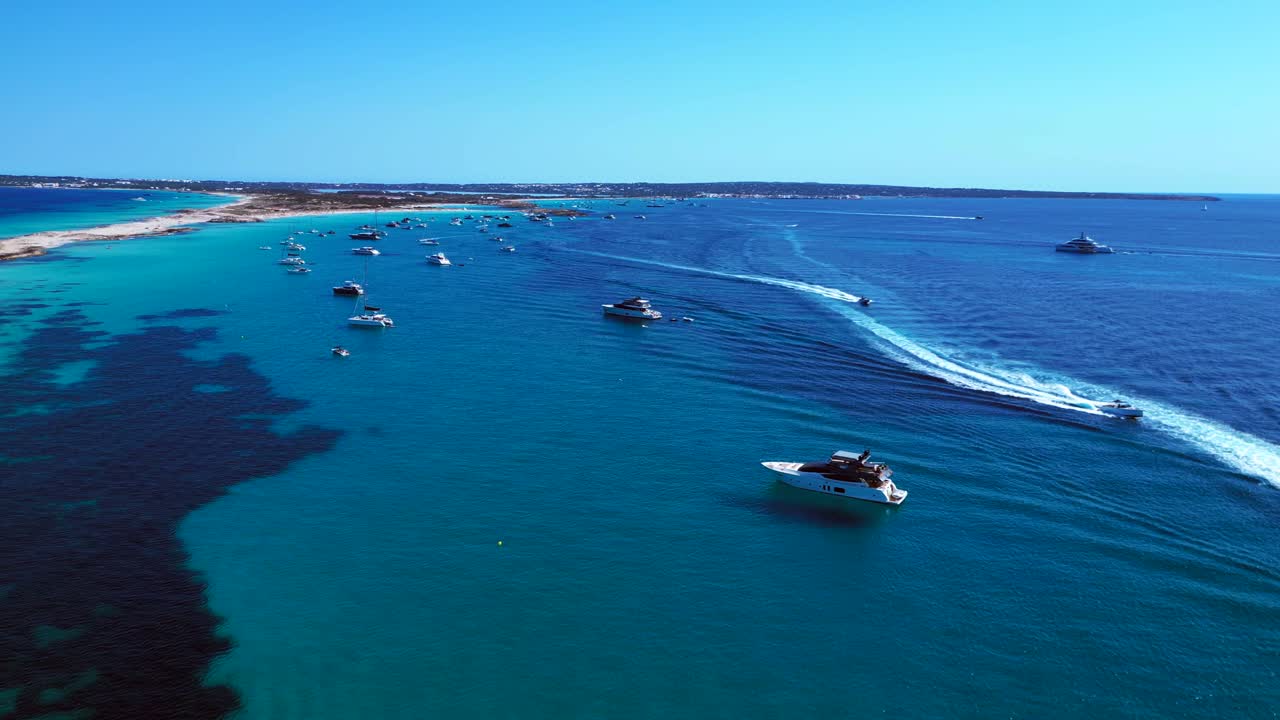 Ibiza Formentera coastline with numerous yachts and boats navigating crystal clear turquoise waters. Unique aerial view flight panorama overview drone