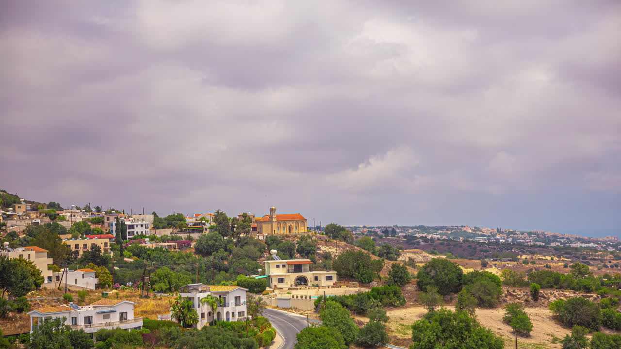 el lapso de tiempo de las nubes nubladas que cubren una pequeña ciudad en la isla de chipre