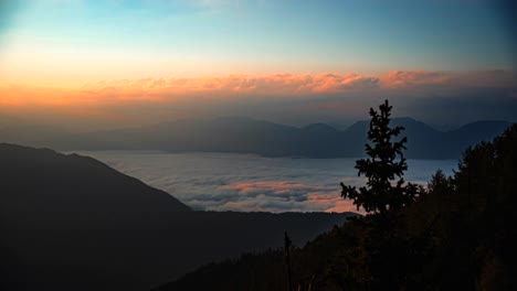 lapso de tiempo de montañas cubiertas de nubes al amanecer en la mañana con hermosos colores en el cielo y el sol subiendo-1