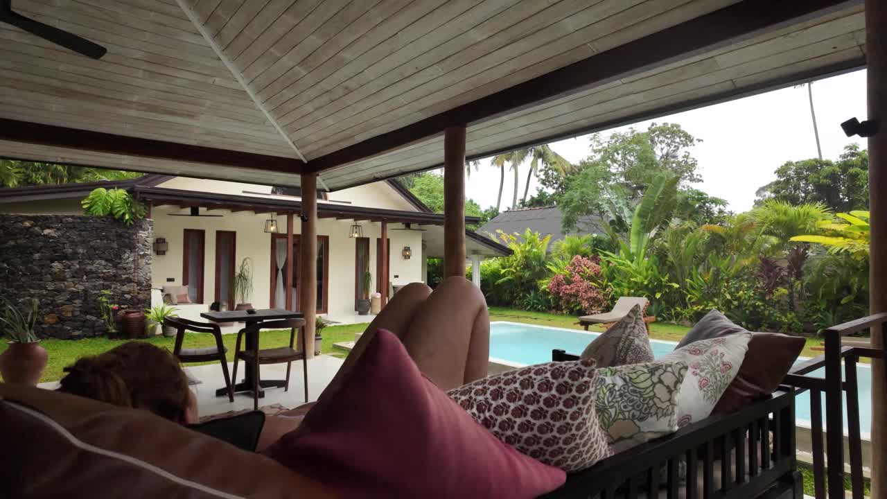 Woman relaxing on lounge Bali bed private luxury pool resort villa Sri Lanka