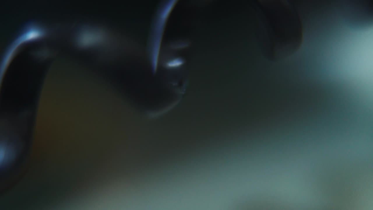 tomada macro de un cable espiral telefónico, cable telefónico viejo negro, deslizamiento a la derecha movimiento suave de la grúa, 120 fps, cámara lenta, full hd