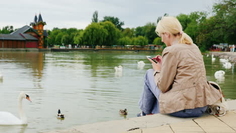 Woman-Uses-Phone-by-Water