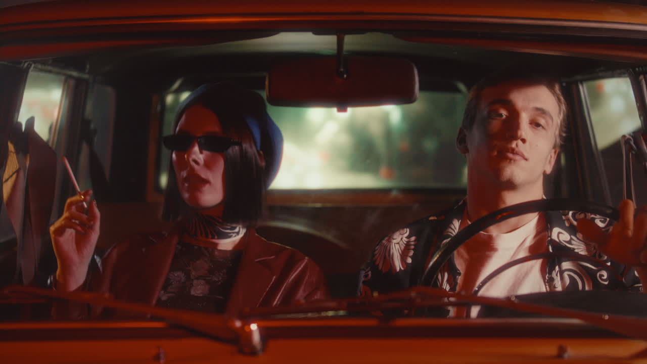 Elegant Woman Smoking during Night Drive with Boyfriend in Vintage Car