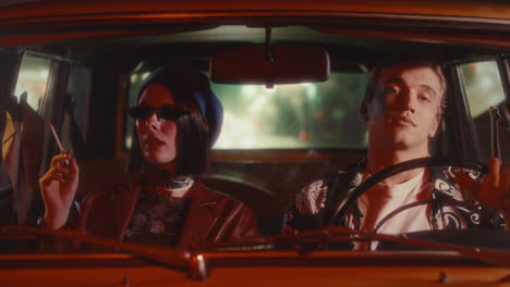 elegant woman smoking during night drive with boyfriend in vintage car