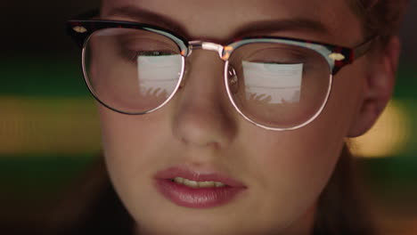 retrato de cerca hermosa mujer de negocios trabajando hasta tarde usando una tableta navegando por datos de gráficos financieros mirando la información en la pantalla usando gafas