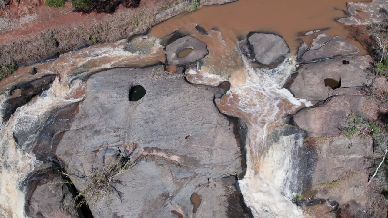 vista aérea de arriba hacia abajo de los flujos de agua sobre las rocas en el bosque